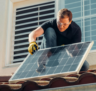 a man installing a second solar panel on his roof